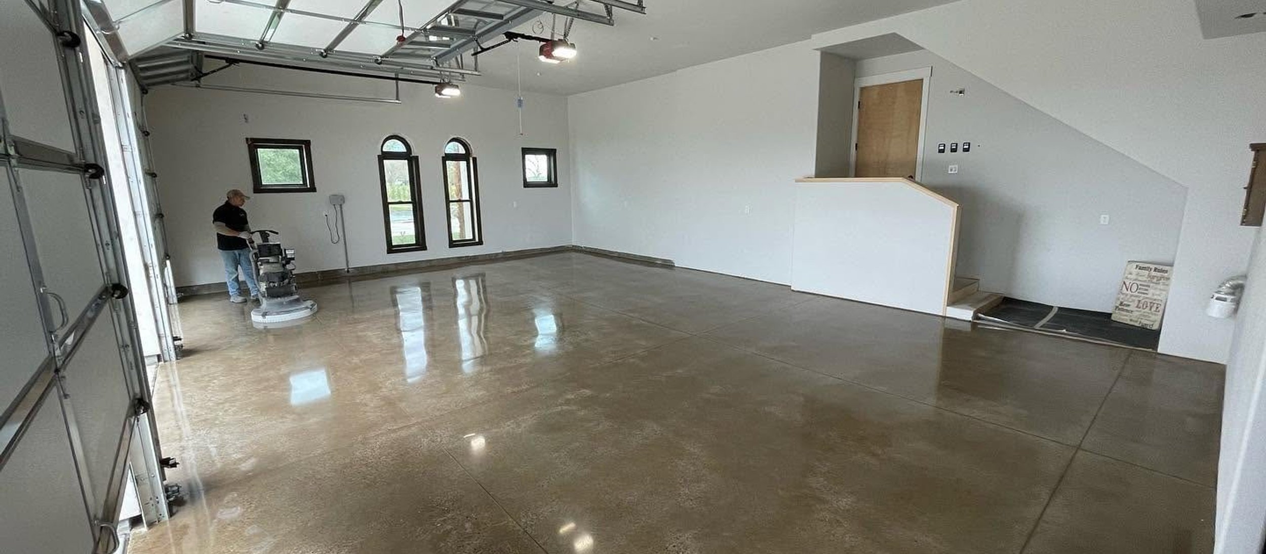 Technician polishing a concrete floor in a residential space
