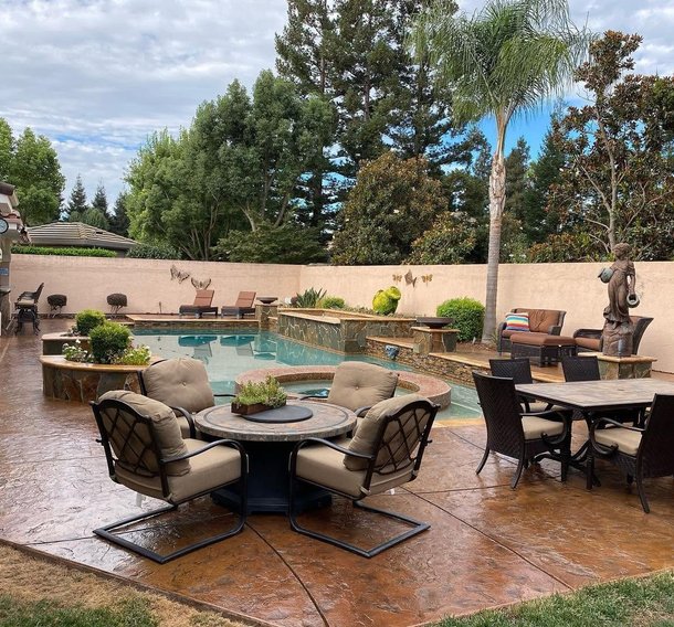 Stained concrete patio around a backyard pool